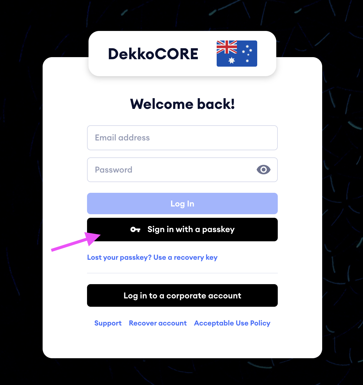 Login screen for DekkoCORE with an arrow pointing to the "Sign in with a passkey" button, below the Log In button.