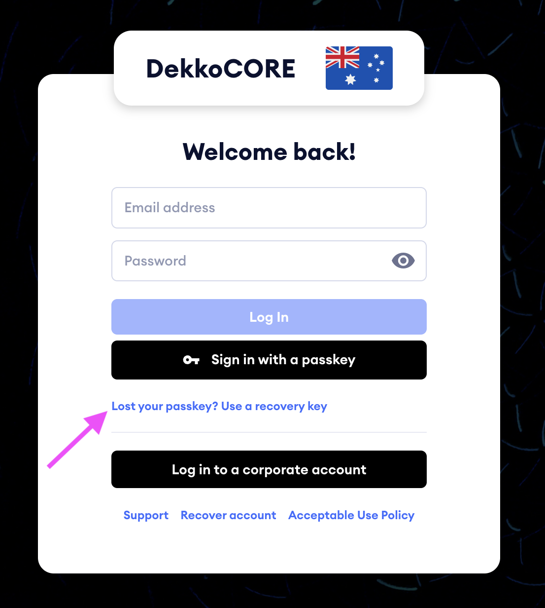 Login screen for DekkoCORE with a "Lost your passkey? Use a recovery key" link highlighted by a pink arrow.
