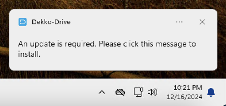 A Windows 11 notification from DekkoDrive reading "An update is required. Please click this message to install," shown above the taskbar clock.